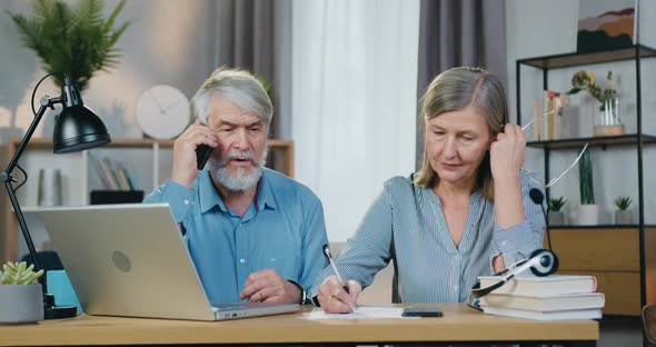Aged Man Talking on Mobile while Woman Taking Notes