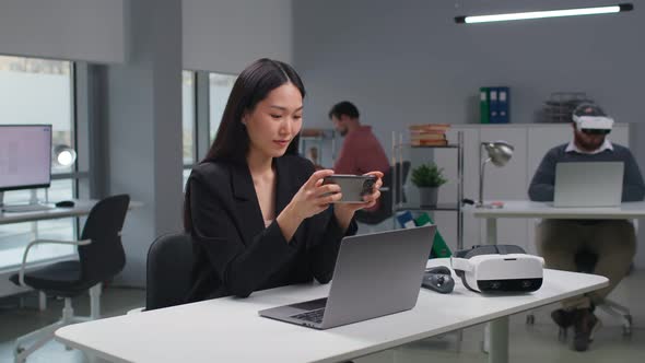 Asian Corporate Manager Play Video Game on Smartphone at Workplace