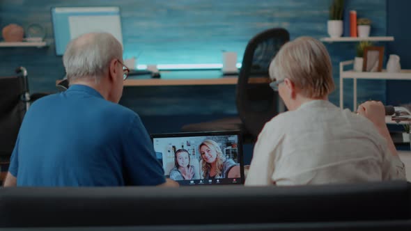 Elder Couple Using Online Teleconference to Chat with Relatives