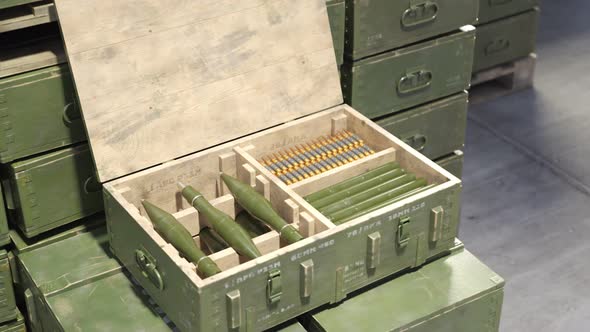 Closeup view at a military box with rifle ammo and RPG missiles in warehouse.