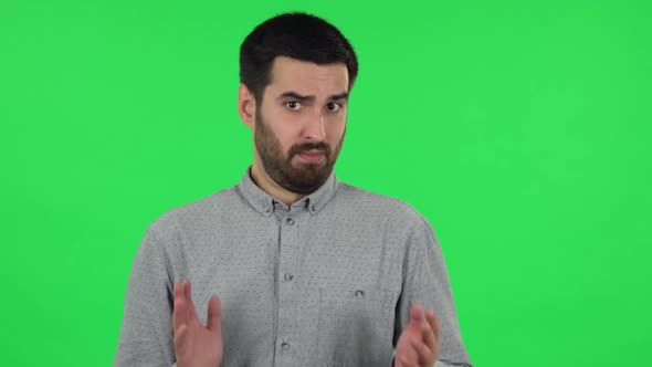 Portrait of Brunette Guy Is Shrugging and Sighing. Green Screen