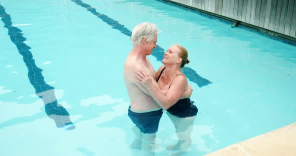 Senior couple embracing romancing in pool