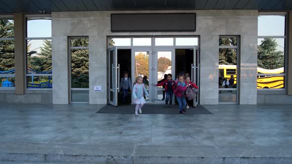 Happy Schoolchildren Running Out of School Doors