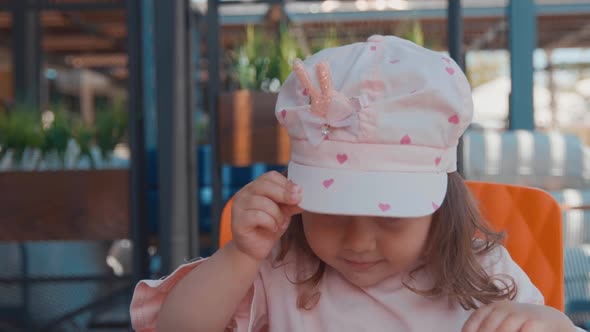 Portrait Of Little Beautiful Girl In Pink Cap Smiling To The Camera