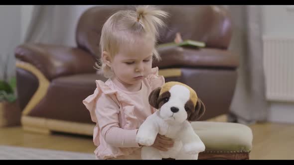 Portrait of Little Beautiful Girl Walking To Camera with Soft Toy Dog