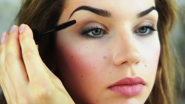 Young Woman Paints Her Eyelashes