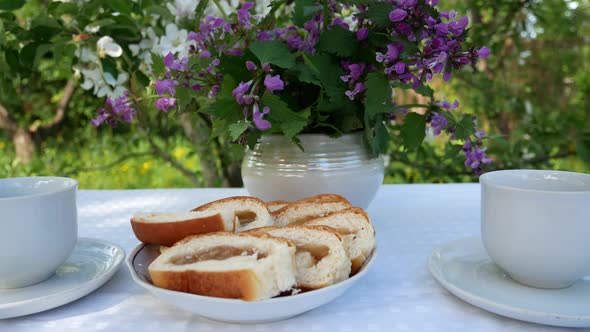 Pie and Two Cups for Tea on a Served Table in the Garden