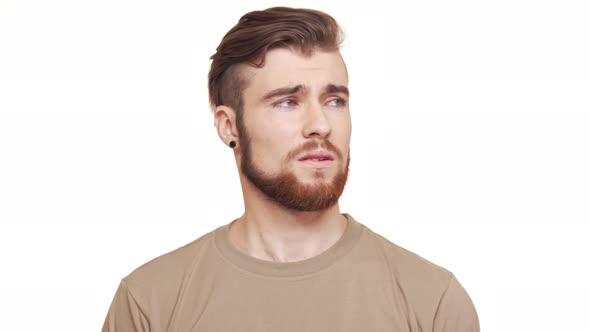 Caucasian Handsome Male in Khaki Tshirt and Brown Beard and Piercing Standing on White Background