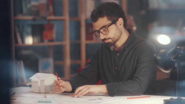 Middle Eastern Architect Drawing Floor Plan and Posing for Camera