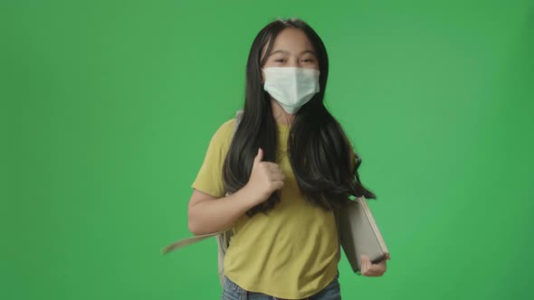 Asian Girl Student Wearing A Mask, Holding Book While Running To School On Green Screen Chroma Key