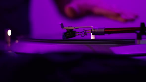 A Vintage Record Player Needle spins a warped and distorted record under a black light while a Disk