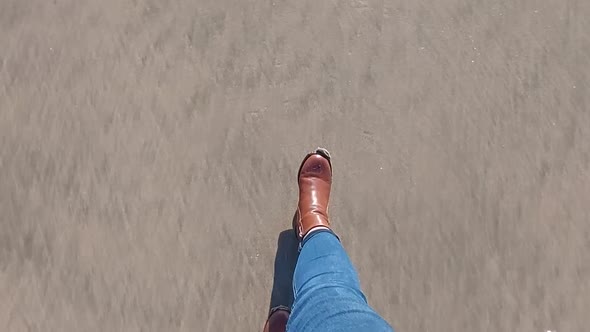 Walking in boots on the sand, loneliness