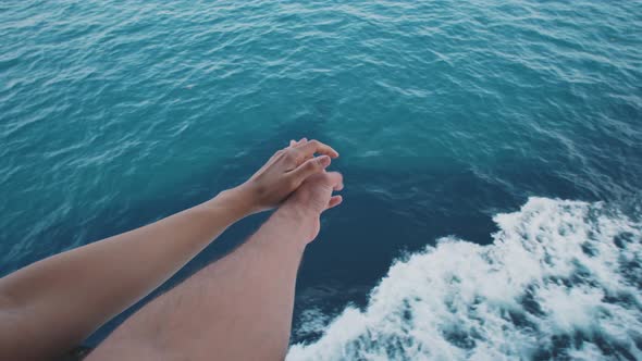 Famale hands crossed over view of sea