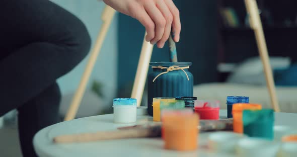 Artist Rinsing Brush in a Jar of Water