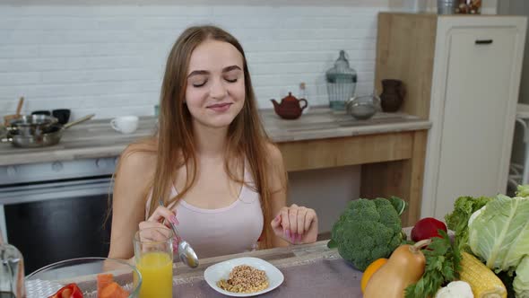 Girl Eating Raw Sprouts Buckwheat with Nuts in Kitchen. Weight Loss and Diet. Healthy Lifestyle