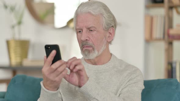 Old Man Using Smartphone at Home 