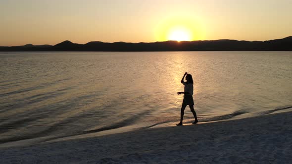 Female Model Walking on the White Sandy Beach of the Clear Tropical Turquoise Sea at Sunset