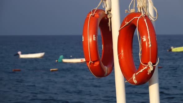 Lifebuoys Hang on the Pier in the Sea Swaying on the Waves of the Boat