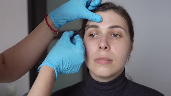 Young Woman Applying Eyebrow Gel to Hairs