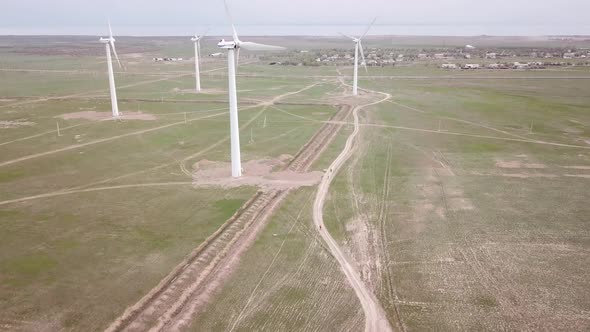 A Group of Cyclists Rides Along the Windmills