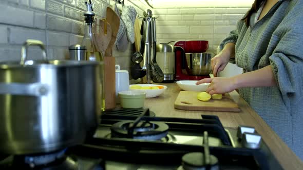 Woman Slice Potatoes on Cut Board