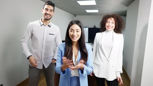 Portrait of Three Positive Multiethnic Businesspeople Waving and Talking at Camera