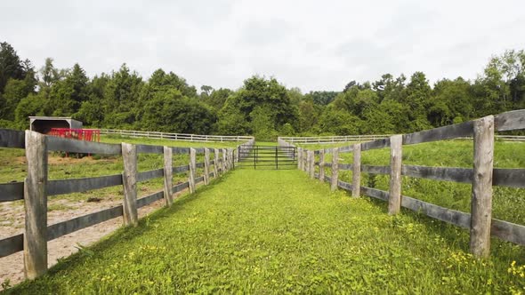 Two pastures with wooden fences on a countryside farm.
