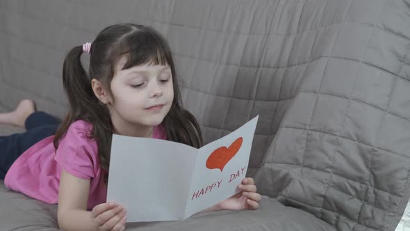 Child with a drawn postcard.