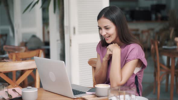 Nice Woman Sitting in Cafe with Laptop Has Video Calling By Webcam