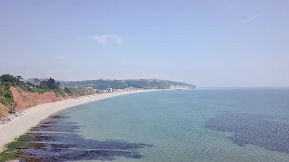 Aerial view of the white sandy beautiful beach in Seaton England. The clear blue water and the warm