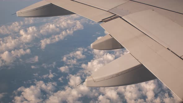 Closeup of Airplane Flying Above Fluffy Clouds