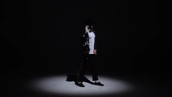 Young Stylish Man Dancing, Spotlight on a Black Background.