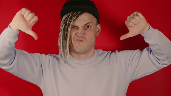 Young Handsome Man in Black Cap Showing Thumbs Down Looking at Camera