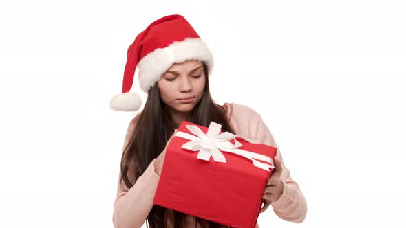 Portrait of Beautiful Woman in Santa Claus Red Hat Being Puzzled Expressing Curiosity While Trying