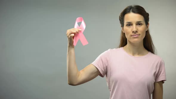 Woman Showing Pink Ribbon Into Camera, International Breast Cancer Awareness