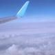 View of the Wing of a Flying Plane High in the Sky Through the Clouds in Sunny Weather - VideoHive Item for Sale