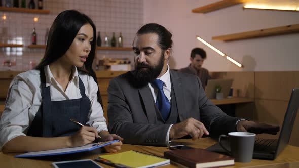 Serious Cafe Manager Giving Work Tasks To Employee