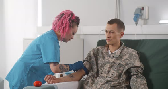 Young Man Soldier Giving Blood in Hemotransfusion Center