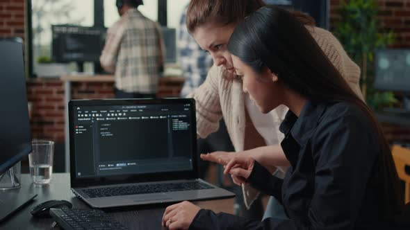 Team of Software Developers Talking About Source Code Running on Laptop Screen