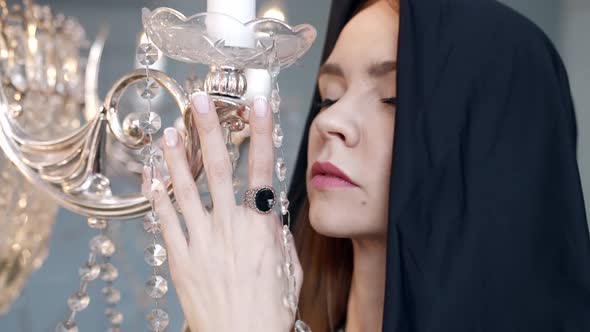 Closeup of a Female Head in a Hood Near the Crystal Pendant Lamp