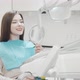 Cheerful Young Woman Smiling to the Camera Sitting in Dental Chair - VideoHive Item for Sale
