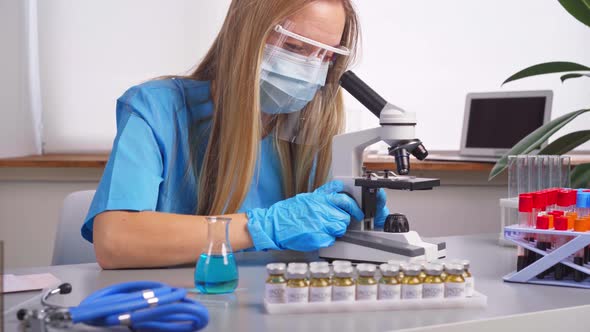 Woman Laboratory Worker Looking Into Microscope