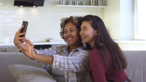 Asian and African American Black Woman Taking Selfie Using Smartphone