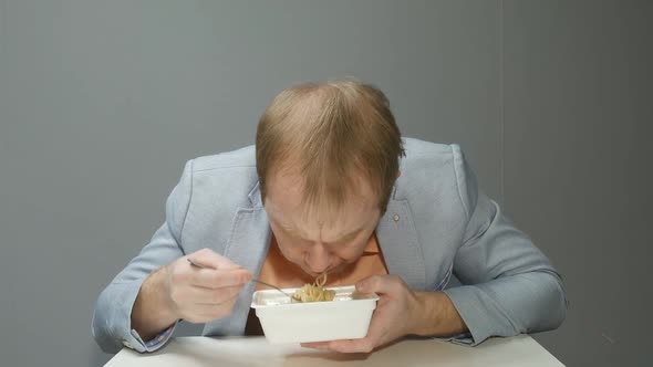 a Young Man Quickly Eats Noodles with a Fork He Is Very Hungry Chews Quickly and Drinks the Broth