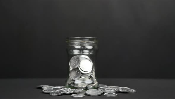 Stop Motion of a Glass Jar Filled With Coins 4K