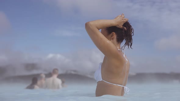 Young Woman Adjusting Hair In Lagoon Geothermal Spa