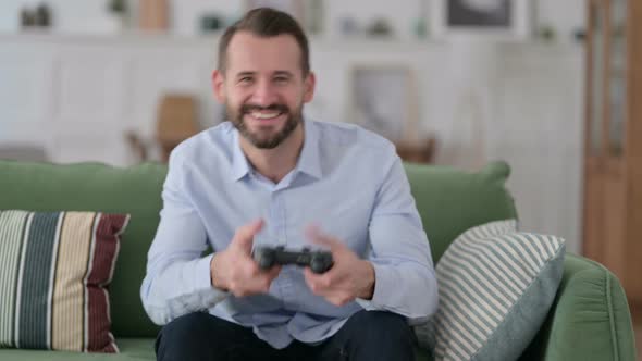 Excited Young Man Playing and Winning Video Game