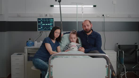 Portrait of Worried Family Looking Into Camera in Hospital Ward During Therapy Consultation