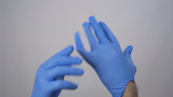 Caucasian Man Putting Medical Protective Gloves On.