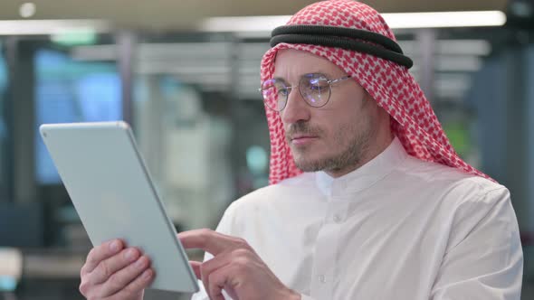 Middle Aged Arab Man using Digital Tablet